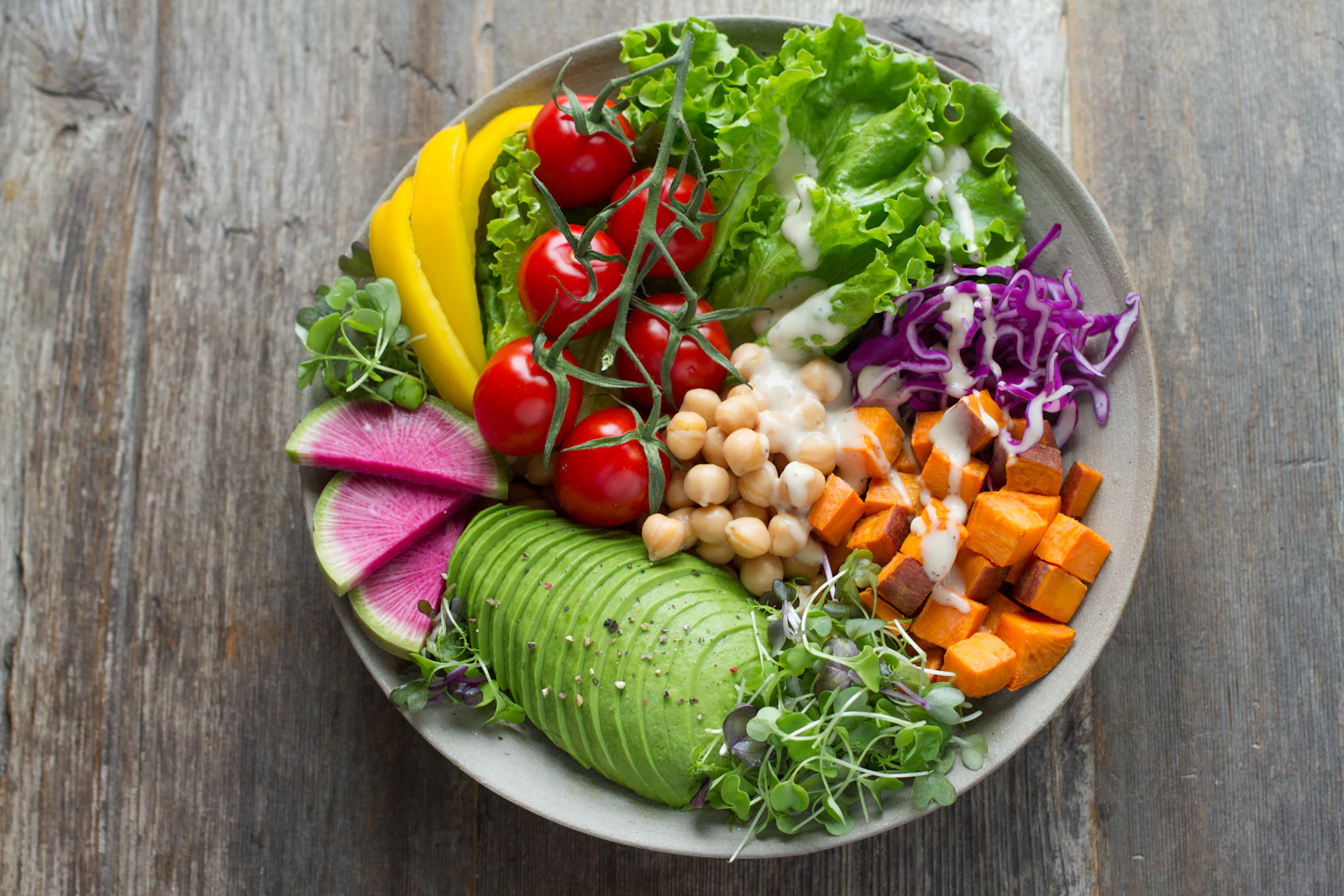 Overhead bowl of fresh vegetables, grains and greens